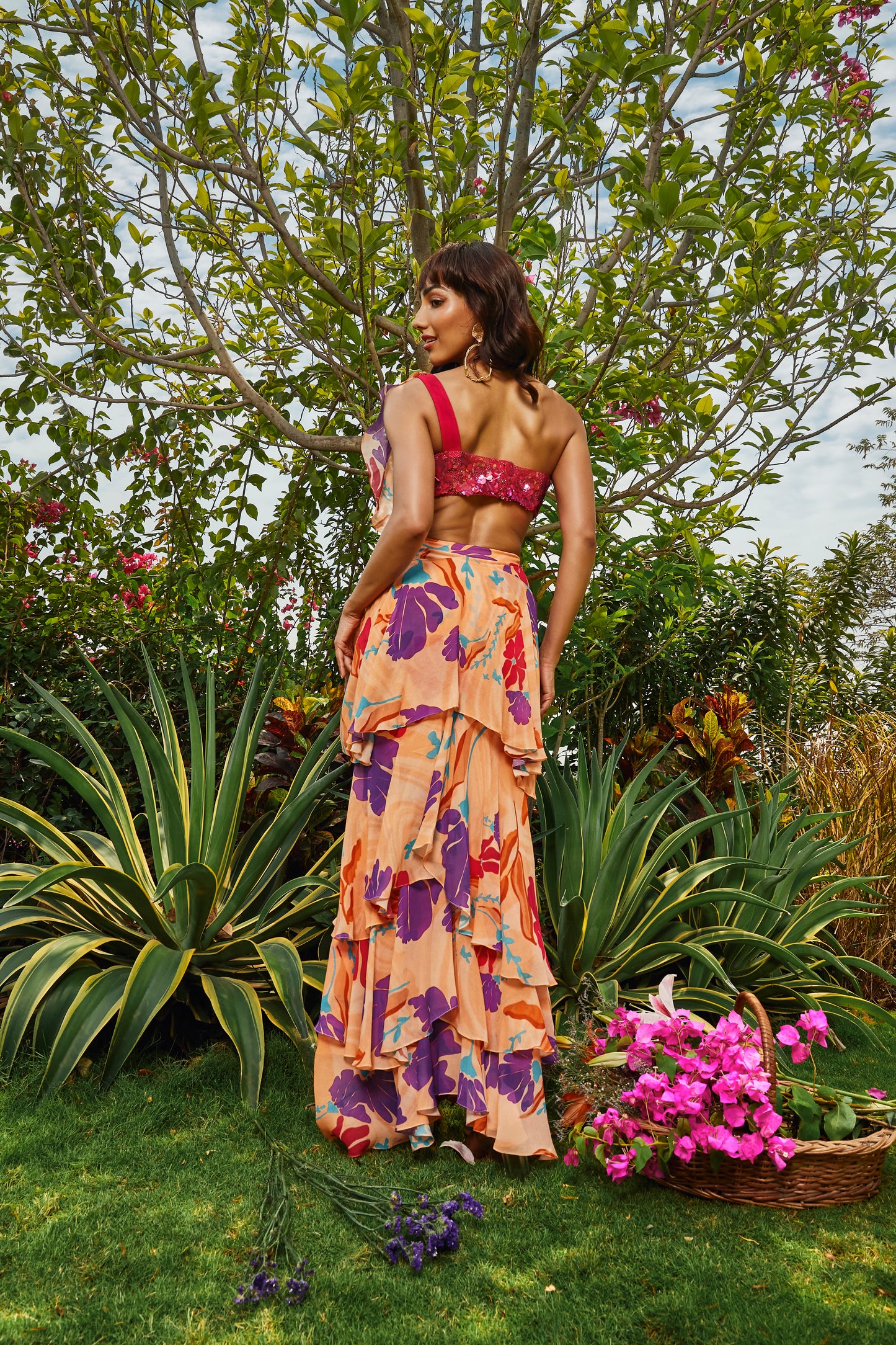 Cerise pink embellished bralette paired with floral printed ruffle saree.