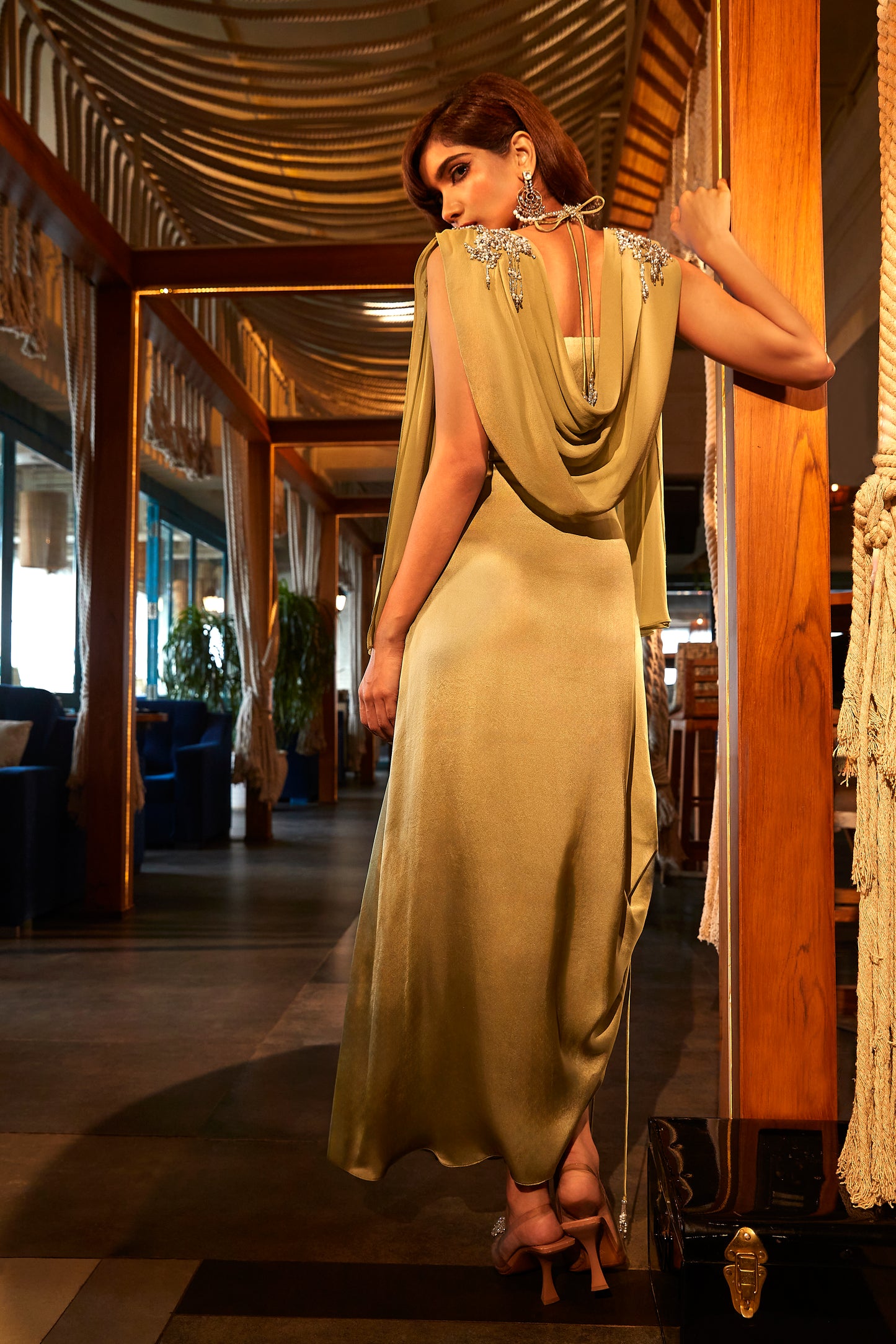 Sage green draped dress teamed with an embroidered cape.